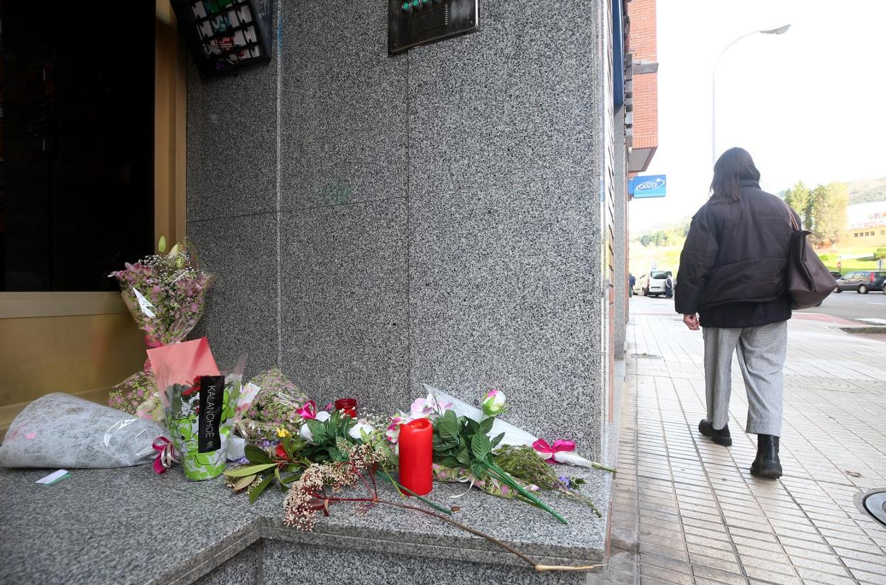 Flores y una vela depositadas en el portal de la calle Vázquez de Mella. 