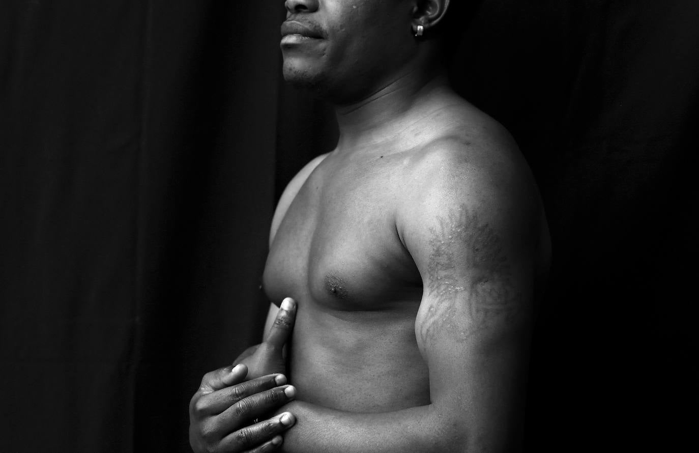 El costalero Roman Aqulino Nguema, 31 años, de Guinea Ecuatorial, técnico en diseño de fabricación mecánica, lleva tatuado en su brazo: "La Cruz en Llamas.