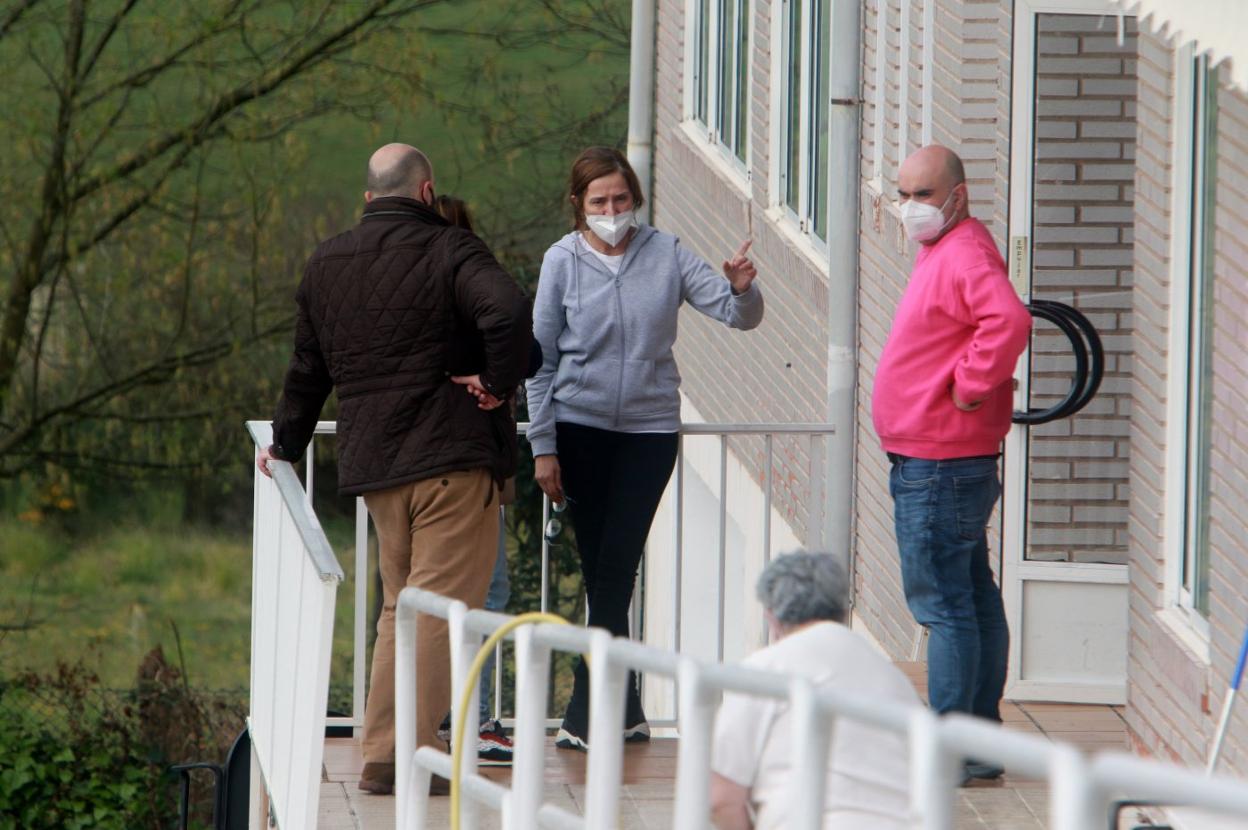 El concejal de Seguridad Ciudadana, Víctor Villa, de espaldas, conversa con representantes de la directiva de la residencia tras ser sofocado el incendio, en el que falleció un residente. 