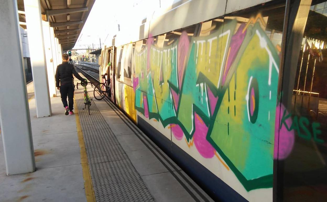 Vagones pintados con graffitis en la estación de tren de Gijón 