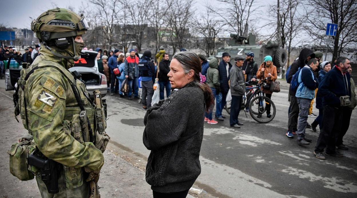 Sin provisiones. Una mujer se planta ante un soldado ruso mientras decenas de personas hacen cola a la espera de la distribución de alimentos. 