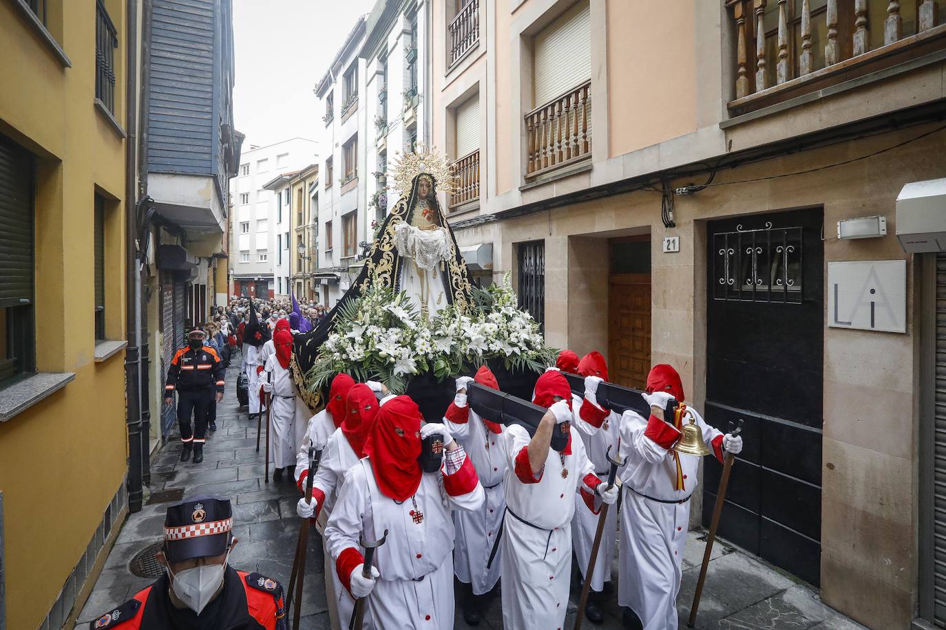 La Ilustre Hermandad de la Santa Vera Cruz abrió camino desde el Campo Valdés para dirigirse a Sebastián Miranda, seguidos por la Hermandad de la Misecordia, portadora de la imagen de San Juan Evangelista y, tras ellos, los integrantes de la Ilustre Cofradía del Santo Sepulcro portaban sobre sus hombros a la virgen de la Soledad, rodeada de flores blancas y ataviada con un manto azul noche y bordados dorados.