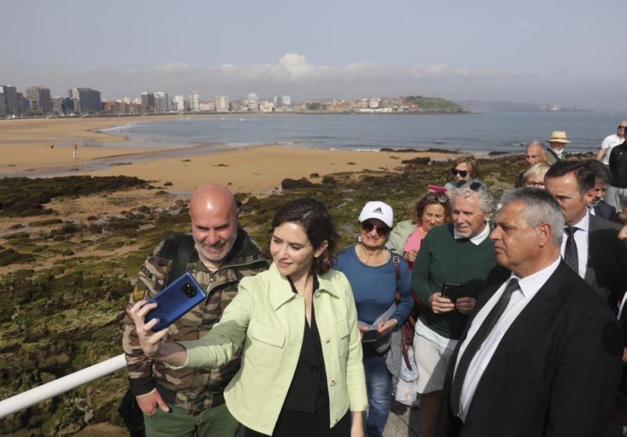 Ayuso se saca un selfi en la ería del Piles, mientras más simpatizantes aguardan su turno. 