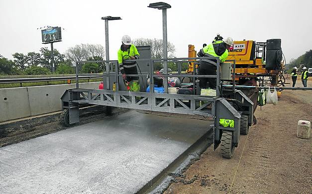 El carro de depurado riega la mezcla para que fragüe. 