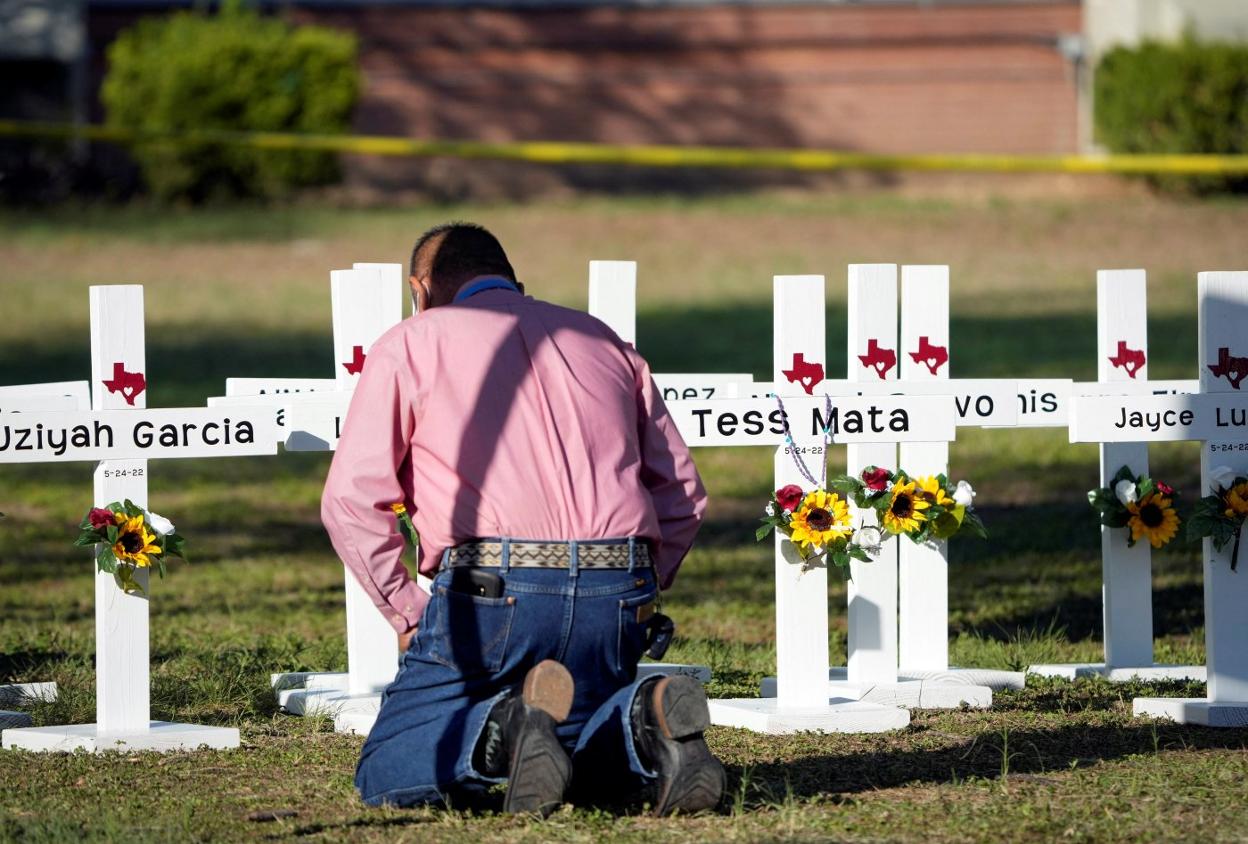 El pastor Daniel Myers reza frente a las cruces funerarias en recuerdo a las víctimas de la masacre cometida el martes en la escuela primaria de Robb, en la localidad de Uvalde (Texas). 