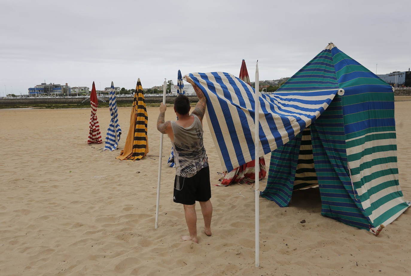 Las 115 casetas autorizadas por la Demarcación de Costas de Asturias para la playa de San Lorenzo ya se encuentran apiladas en el arenal gijonés. Después de dos años de ausencia por las restricciones derivadas de la pandemia sanitaria, las icónicas casetas comenzaron a instalarte este lunes en las escaleras 7, 12 y 14.