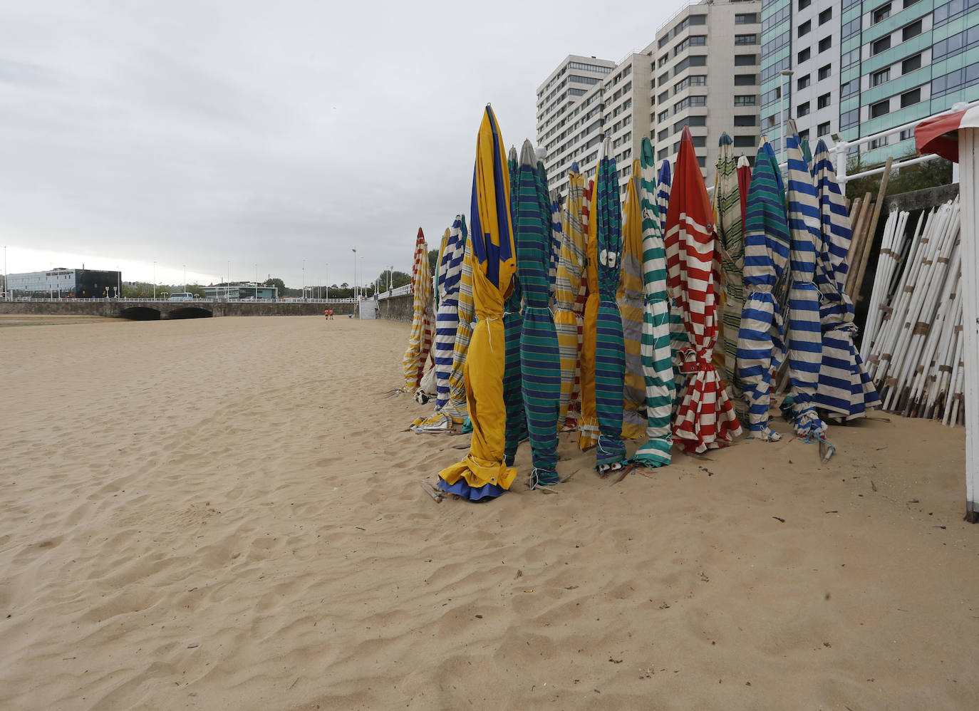 Las 115 casetas autorizadas por la Demarcación de Costas de Asturias para la playa de San Lorenzo ya se encuentran apiladas en el arenal gijonés. Después de dos años de ausencia por las restricciones derivadas de la pandemia sanitaria, las icónicas casetas comenzaron a instalarte este lunes en las escaleras 7, 12 y 14.