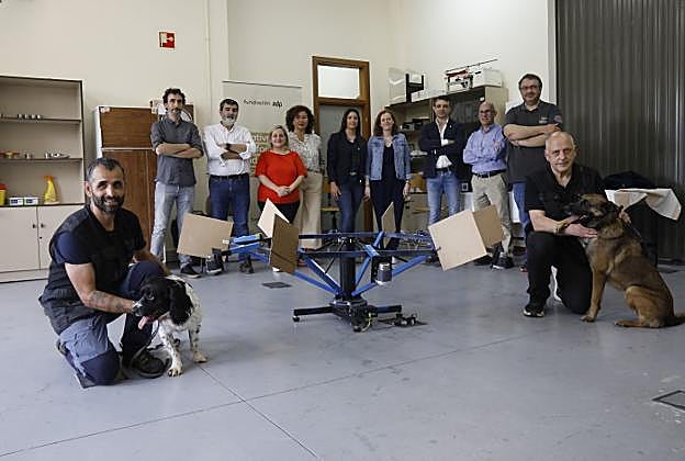 Los investigadores que trabajan en este proyecto, con 'Roy' y 'Nai' ante la rueda de detección desarrollada por el Departamento de Mecánica de la Universidad de Oviedo. 