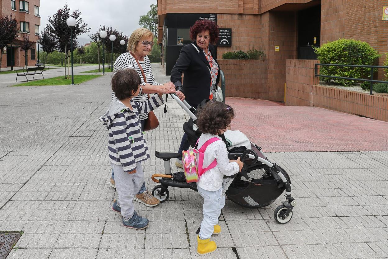 Una abuela pasea con sus nietos por Viesques. 