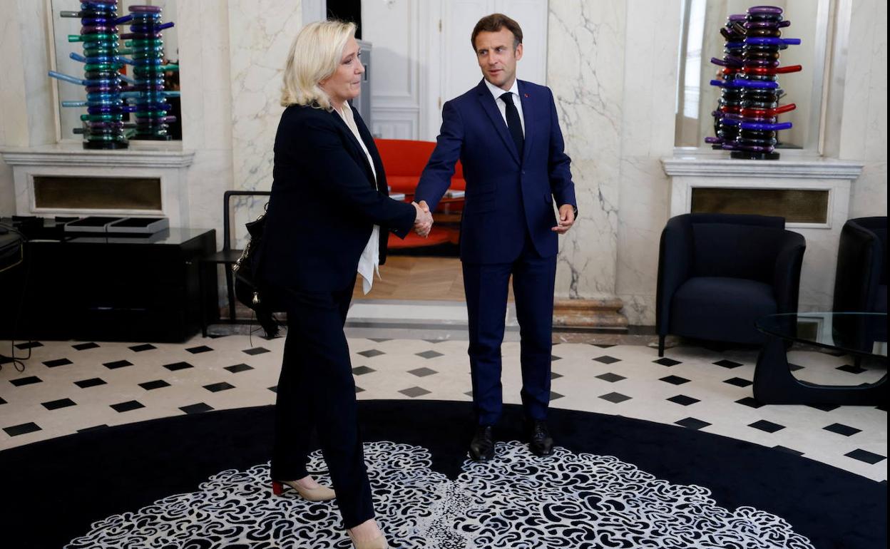 Marine Le Pen saluda, este martes, a Emmanuel Macron antes de reunirse en el Palacio del Elíseo.