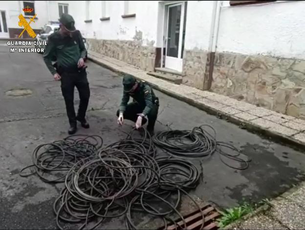 Dos agentes de la Guardia Civil comprueban el cable de cobre robado. 