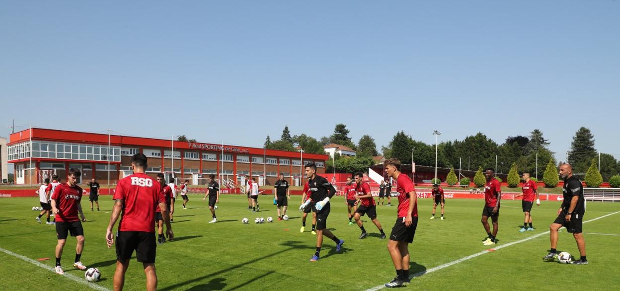 Los jugadores del Sporting realizan un ejercicio de circulación de balón, durante el entrenamiento de ayer, bajo la atenta mirada de Abelardo, a la derecha. 