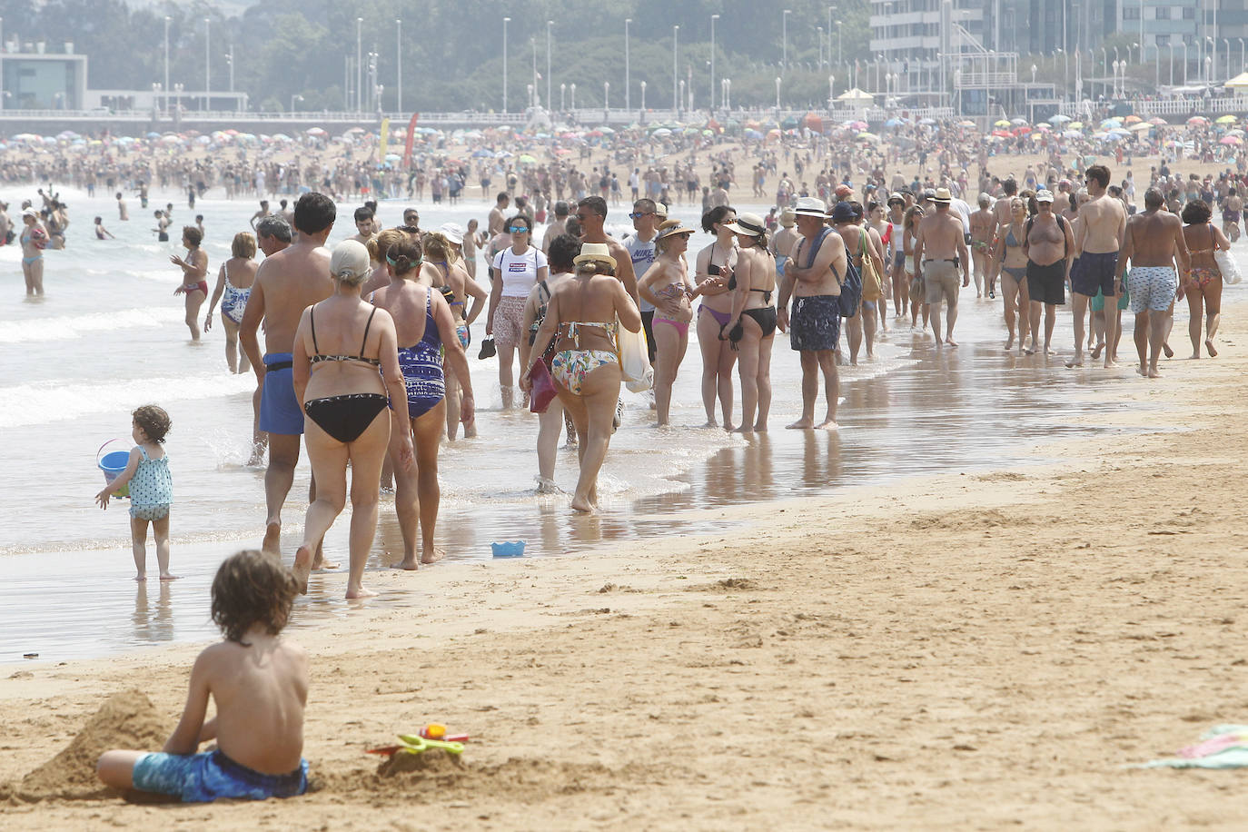 En la imagen, bañistas en la playa de San Lorenzo. | En el vídeo, recomendaciones durante la ola de calor. 