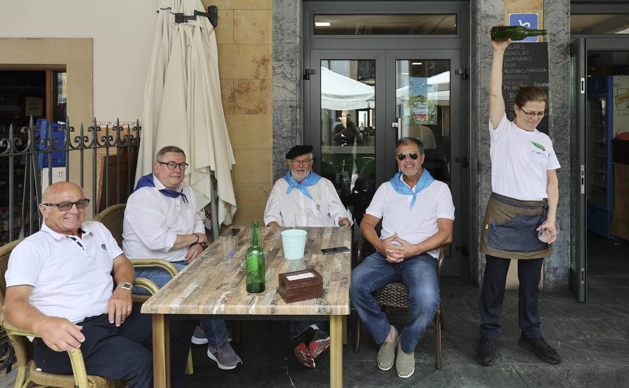 Un grupo de personas disfrutan de la festividad en una terraza.
