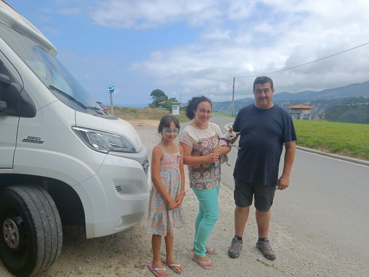 Daniela, Eva -con su perrita 'Cloe' en brazos- y Fernando, ante su caravana en La Regalina. 