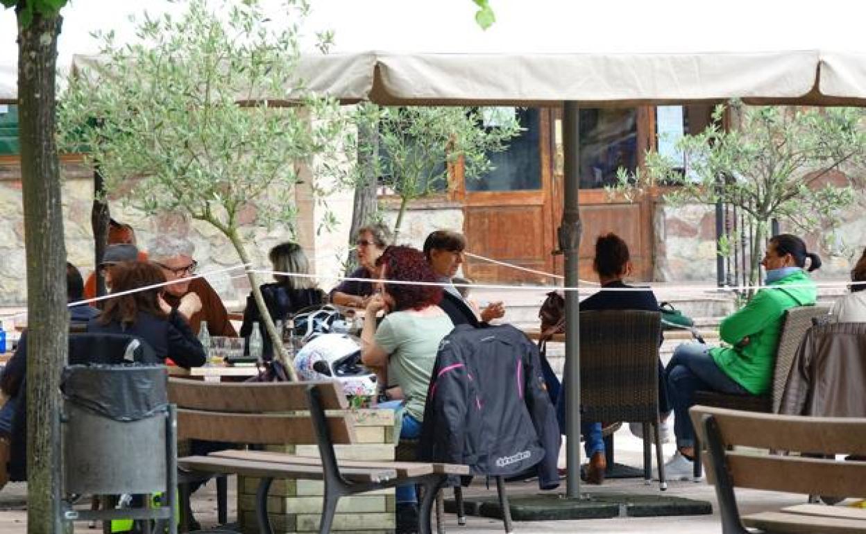 Unos clientes toman algo en una terraza cualquiera