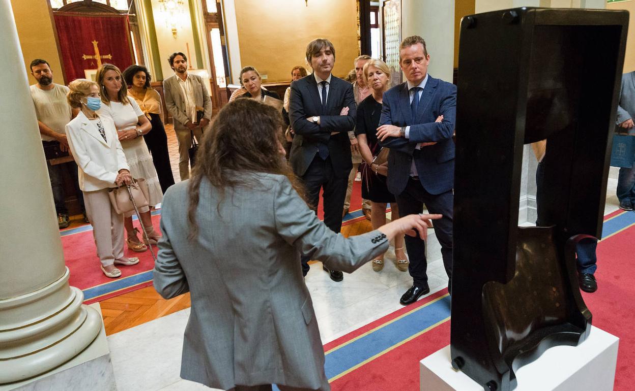 La comisaria de la muestra, Sara Moro, revela los detalles de una de las obras a los asistentes a la inauguración, entre ellos el presidente de la Junta, Marcelino Marcos Líndez, y el director del Museo de Bellas Artes de Asturias, Alfonso Palacio. 