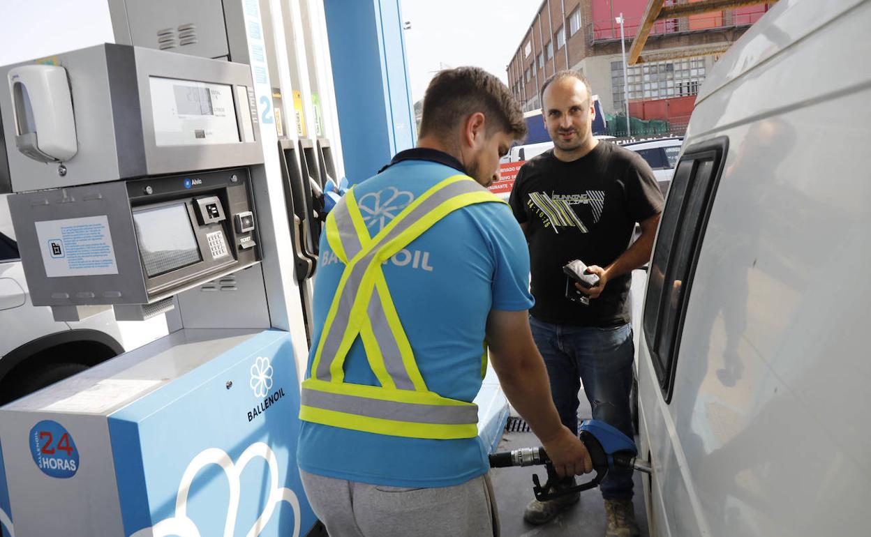 Un trabajador de una estación de servicio de Gijón reposta el vehículo de un cliente. 