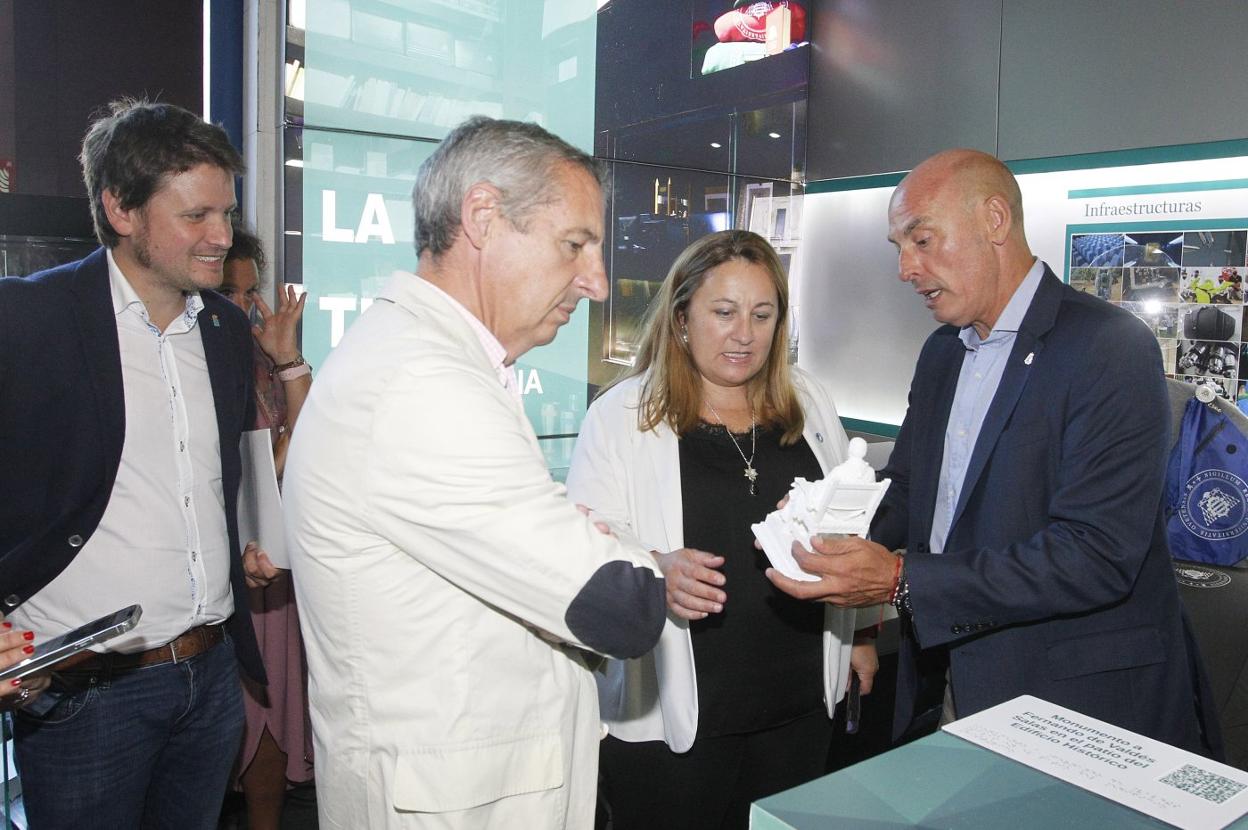 David Artime y Lydia Espina atienden a las explicaciones del vicerrector de Profesorado, Pedro Alonso, en el estand de la Universidad, en presencia del vicepresidente de la Cámara de Gijón, Pedro López Ferrer. 