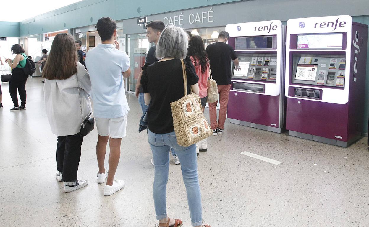 Varios ciudadanos adquieren el abono de Renfe en la estación de tren de Gijón