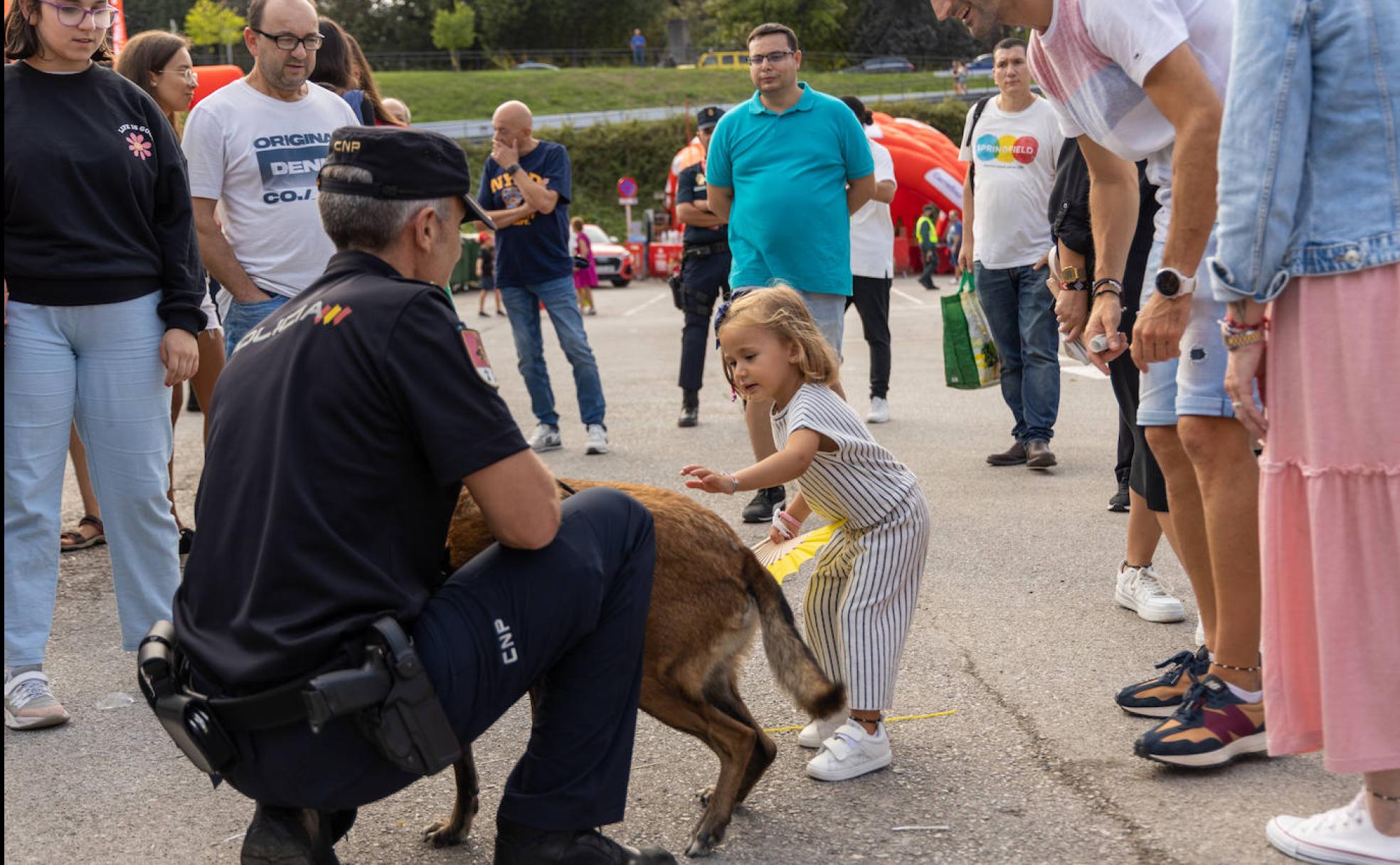 Una niña acaricia a uno de los perros de la unidad de Guías Caninos.