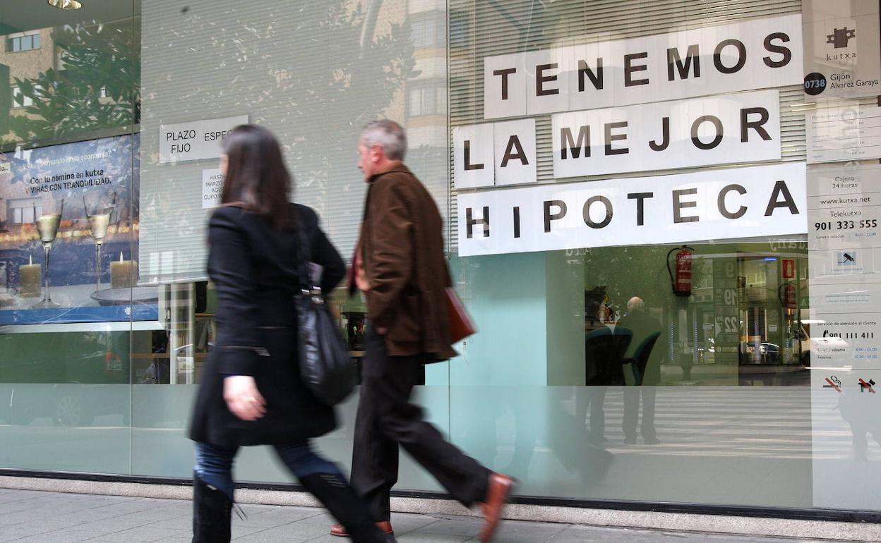 Viandantes ante el escaparate de un banco. 