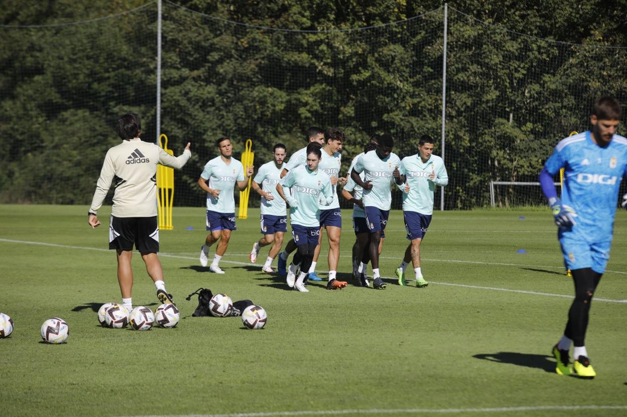 Los jugadores azules corren por uno de los campos. 
