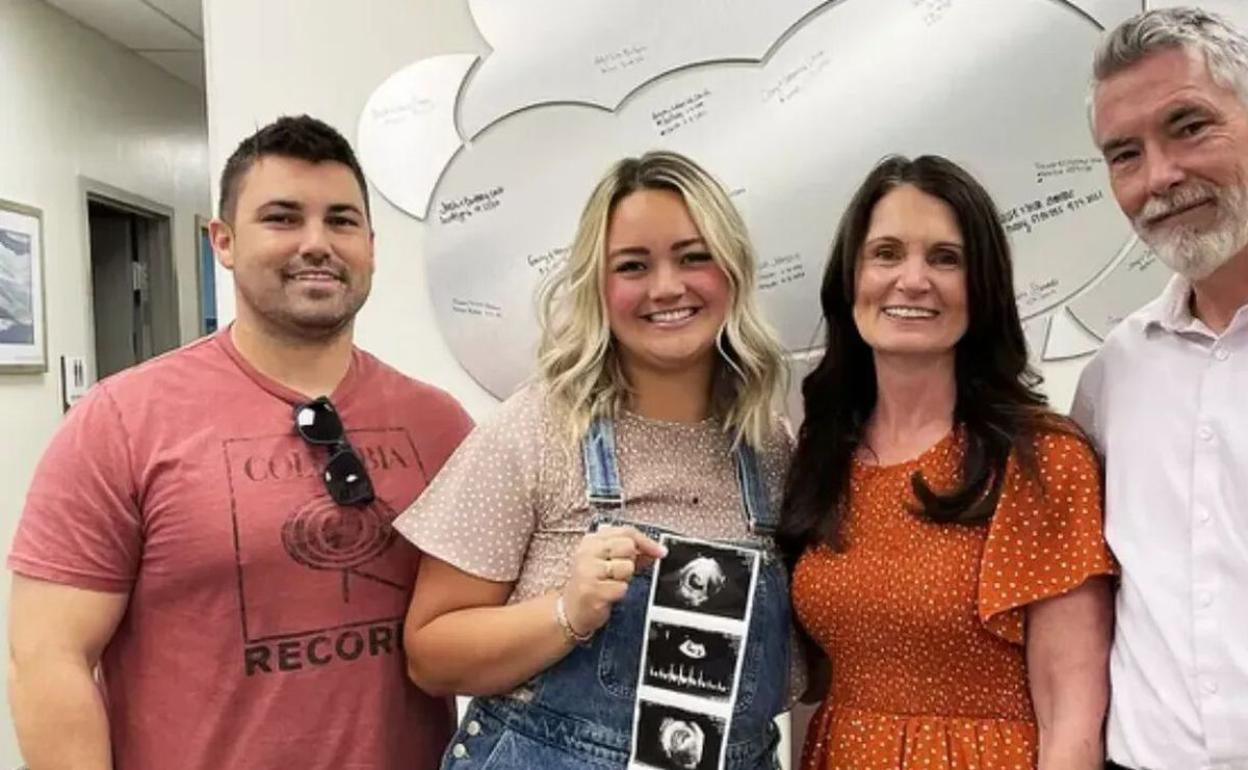 Nancy Hauck, junto a su nuera Cambria, su hijo Jeff y su marido, mostrando fotos de la nieta que nacerá en noviembre.