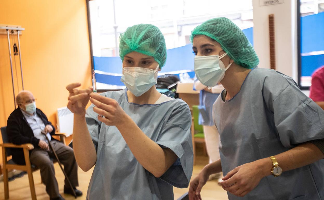 Unas enfermeras preparan los viales para administrar una dosis de la vacuna contra la covid a los usuarios de una residencia de ancianos de Avilés.