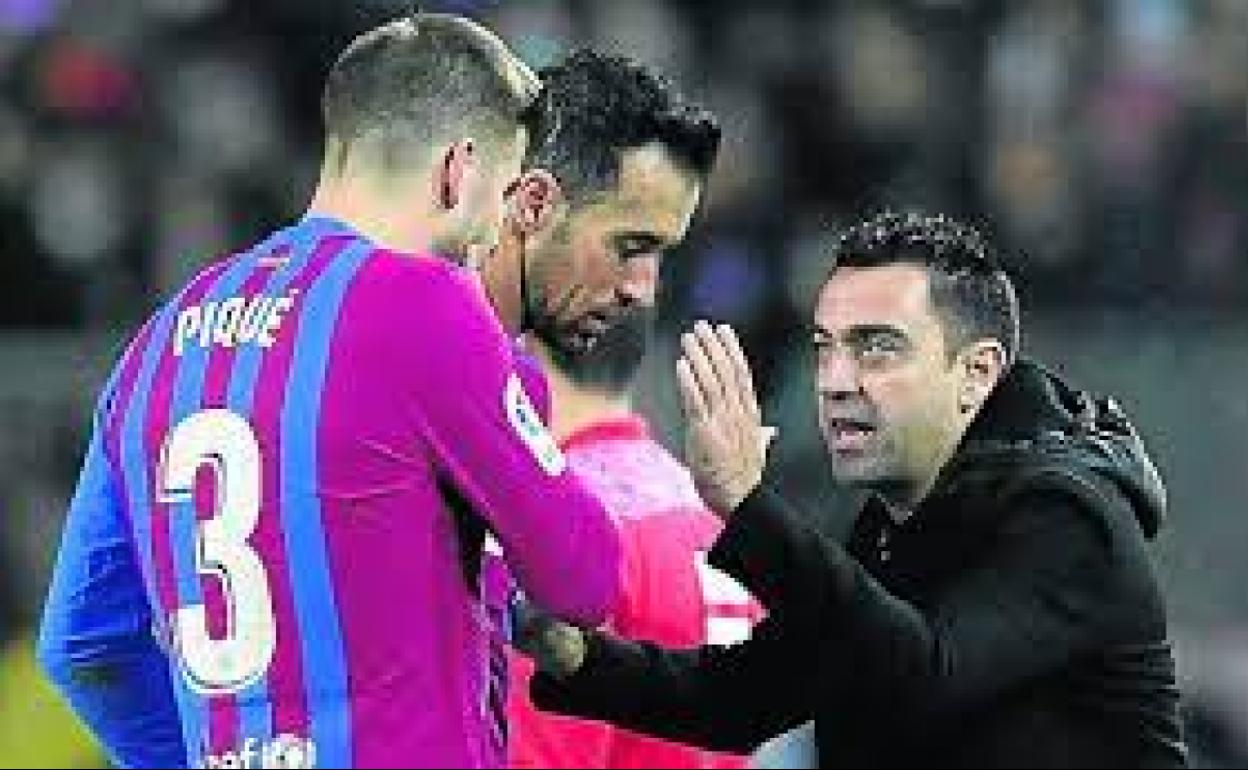 Xavi Hernández se dirige a Gerard Piqué. 