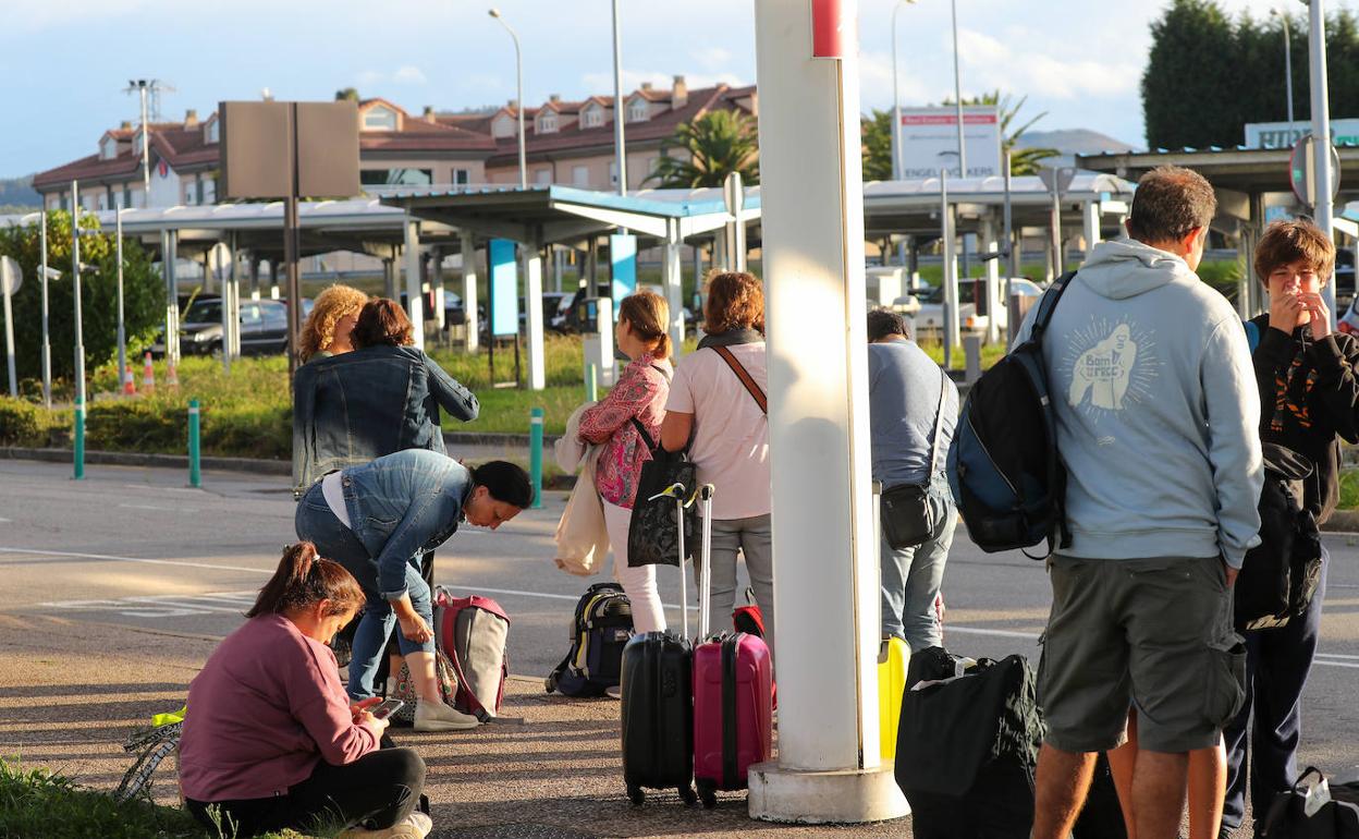 Pasajeros esperando lel transporte de vuelta, tras el cancelamiento de su vuelo.