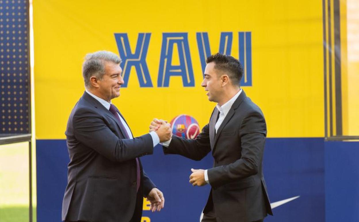 Joan Laporta y Xavi Hernández se saludan durante la presentación del entrenador. 