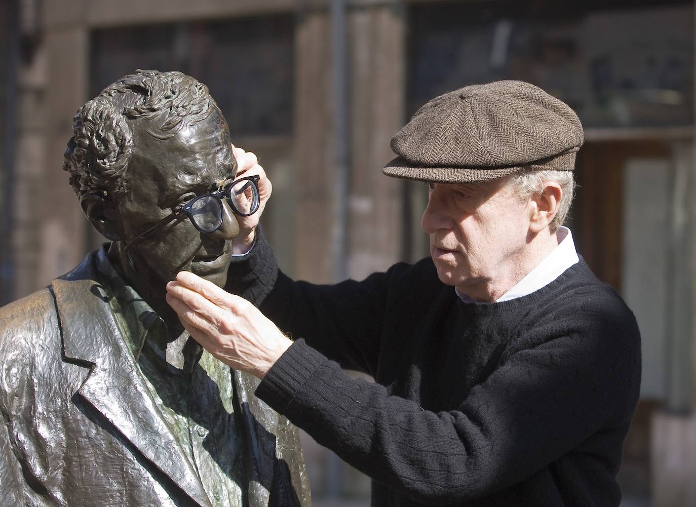 Woody Alllen colocando sus gafas en su estatua conmemorativa durante una de sus visitas a Oviedo