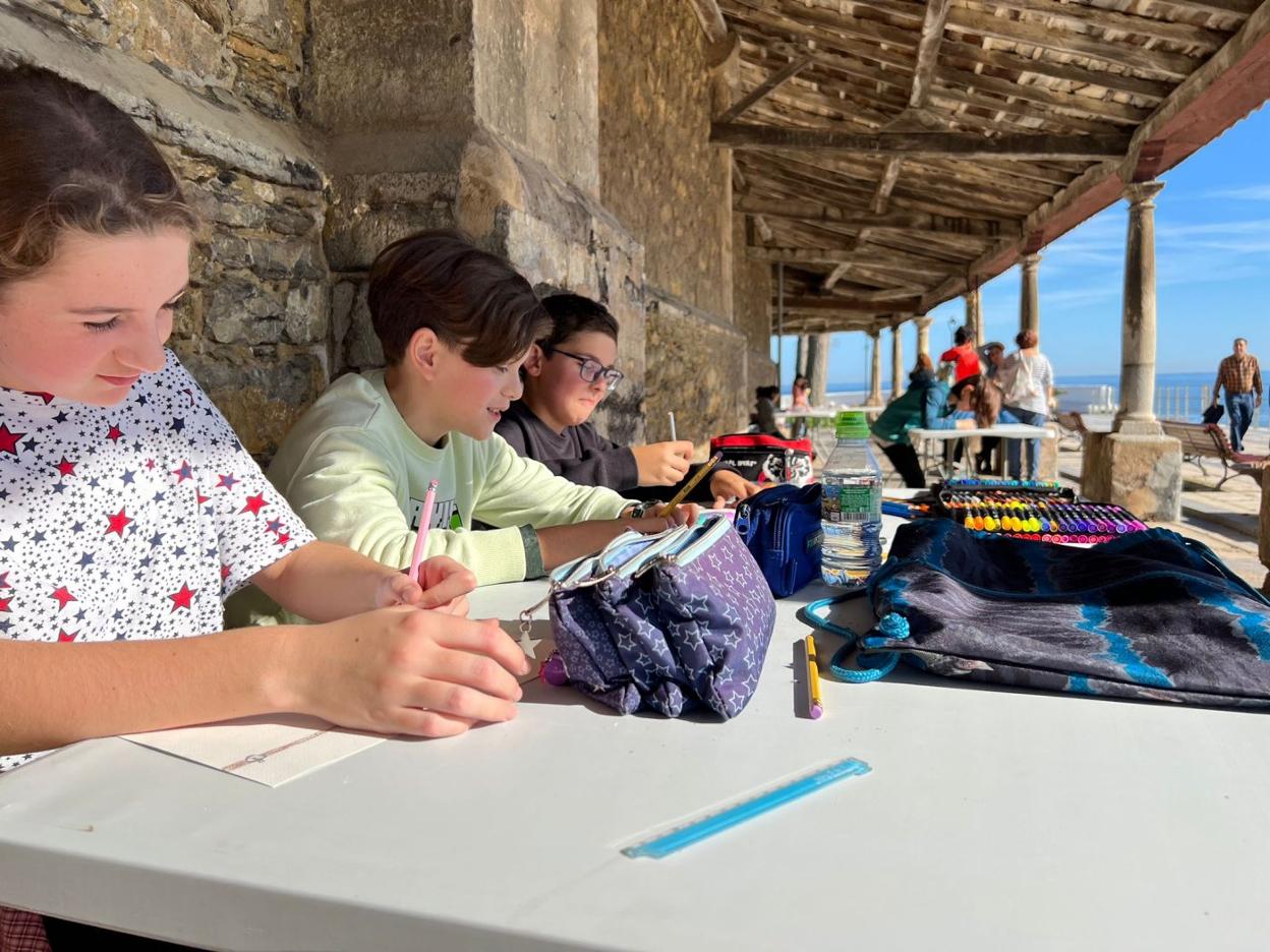 Tres participantes hacen sus dibujos en el cabildo de la iglesia. 