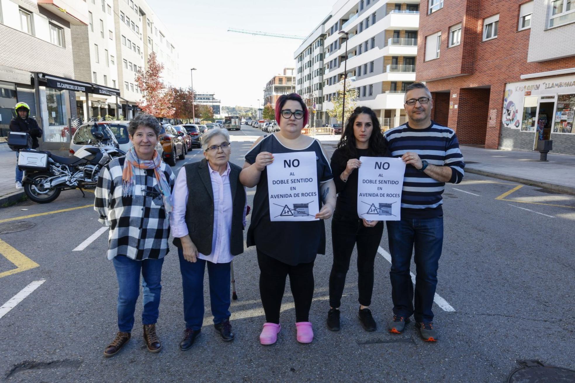 Comerciantes de Nuevo Roces muestran el cartel diseñado en su día para oponerse al doble sentido de la avenida. 