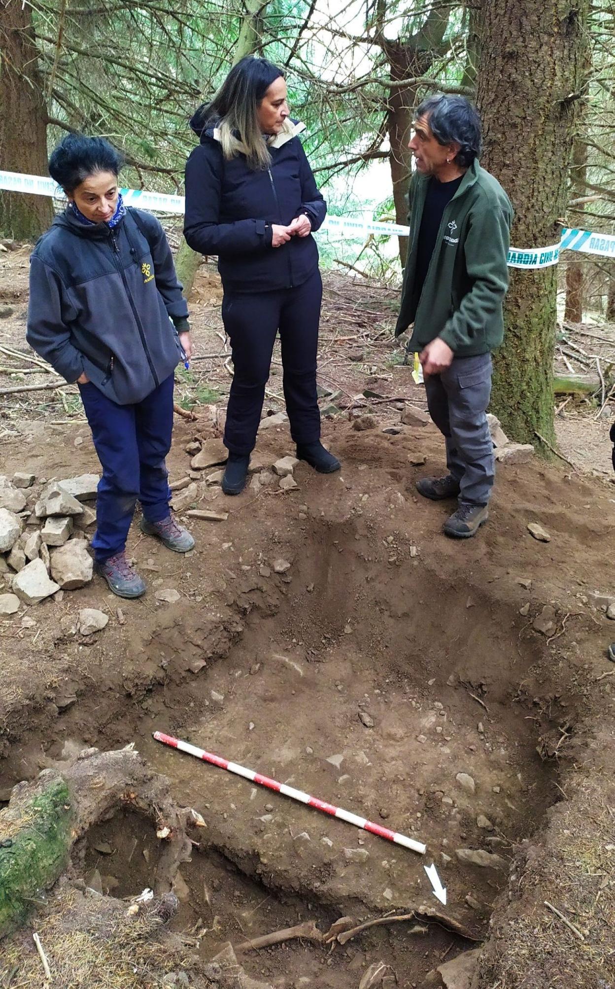 La antropóloga Lourdes Herrasti, Rita Camblor, y el arqueólogo Antonio Martínez, en la fosa de Parasimón. 