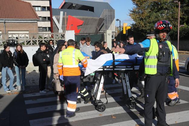 Los sanitarios trasladan a la ambulancia al motorista herido. 