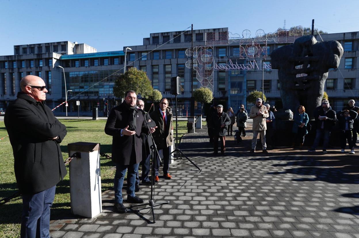 Barbón se dirige a los presentes, con el campus de Barredo al fondo. En primer término, el presidente de la asociación cultural Santa Bárbara. 