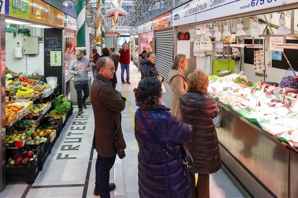 Varios compradores aguardan su turno en el Mercado del Sur, de GIjón. 