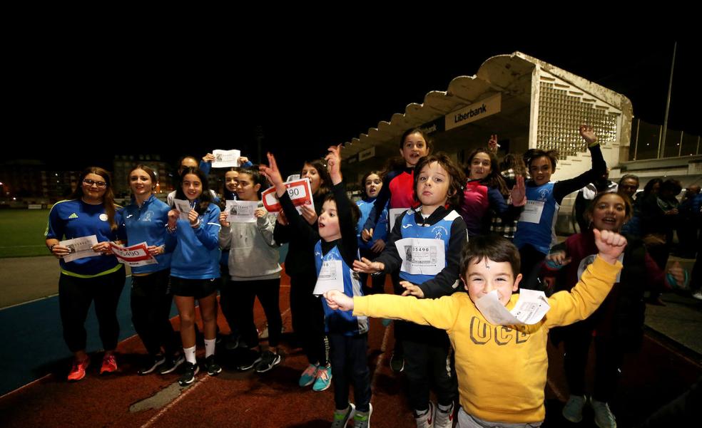 Niños del club de Atletismo de Mieres celebran la lluvia de millones.