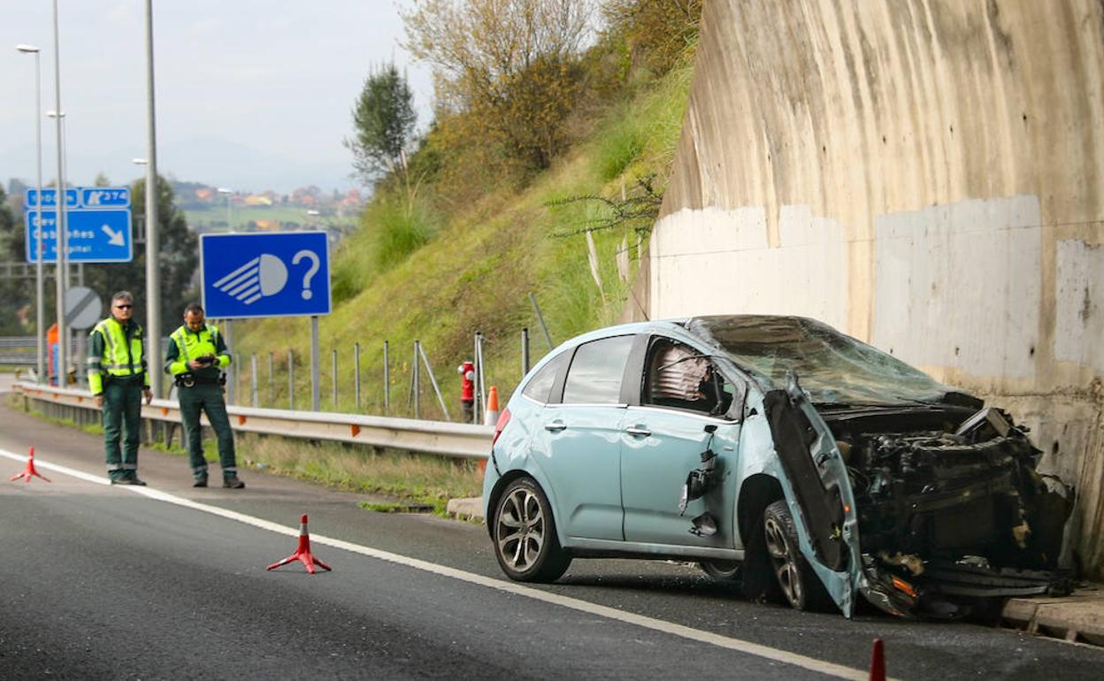 Dos agentes regulan el tráfico tras el accidente, que dejó la parte delantera del coche siniestrada. 