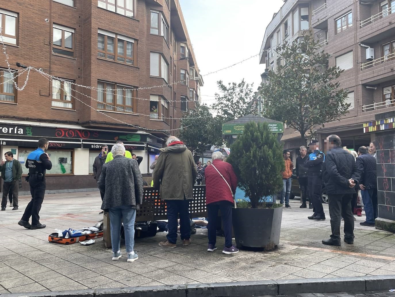 Familiares y vecinos, arremolinados junto al hombre en en la plaza de La Pomar.