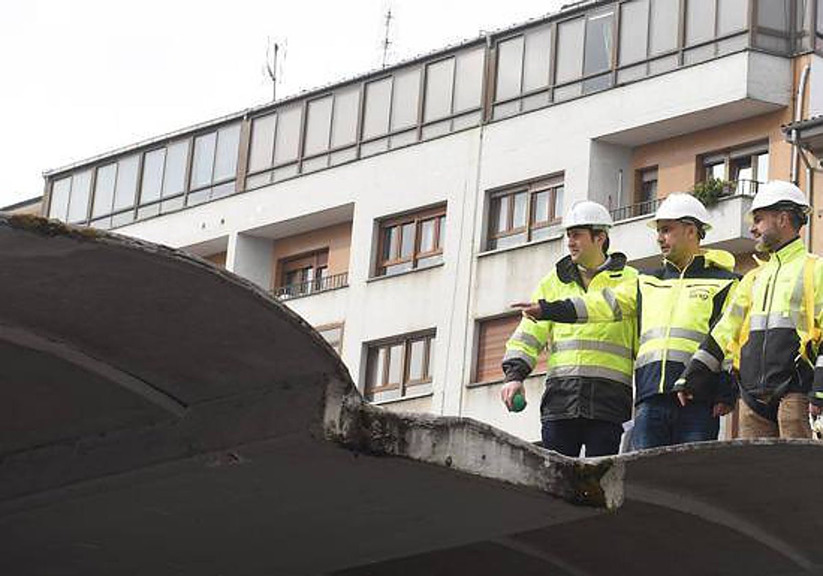 El aparejador municipal, Ángel Freire, el concejal de Infraestructuras Urbanas y el alcalde de Siero, ayer, en el tejado de la plaza cubierta.