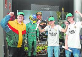 Sergio Gancedo, Jonathan Honrado e Hidalgo García posan con el mono y el casco con el que Fernando logró el primer podio de la actual temporada