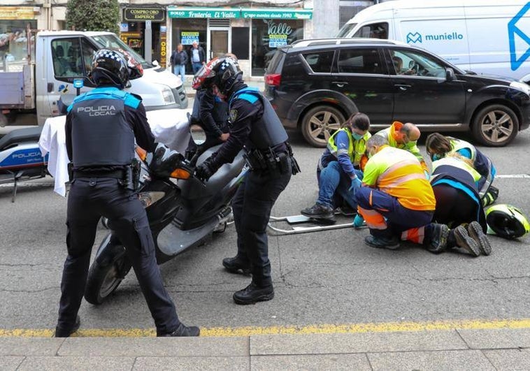 Policías locales y sanitarios atienden al motorista herido en la calle Ramón y Cajal.