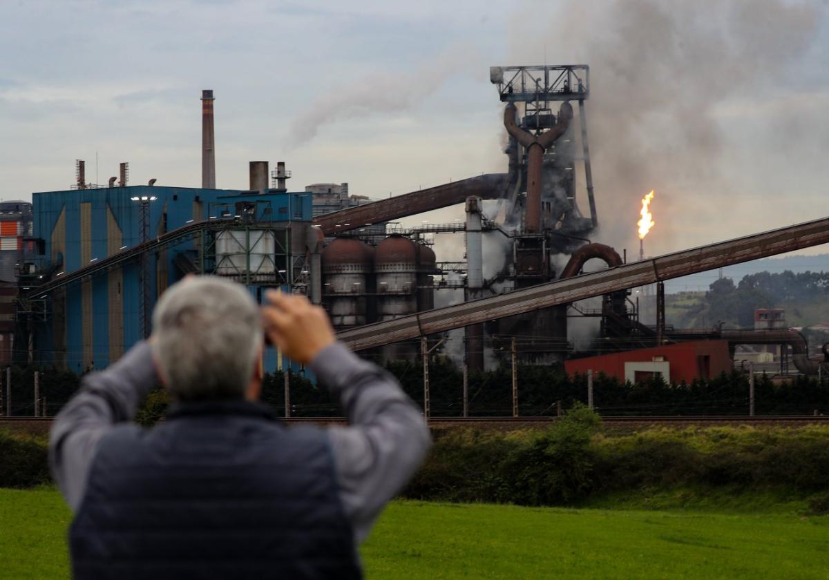 Un hombre fotografía el horno alto 'A', envuelto en el humo provocado por el incendio.