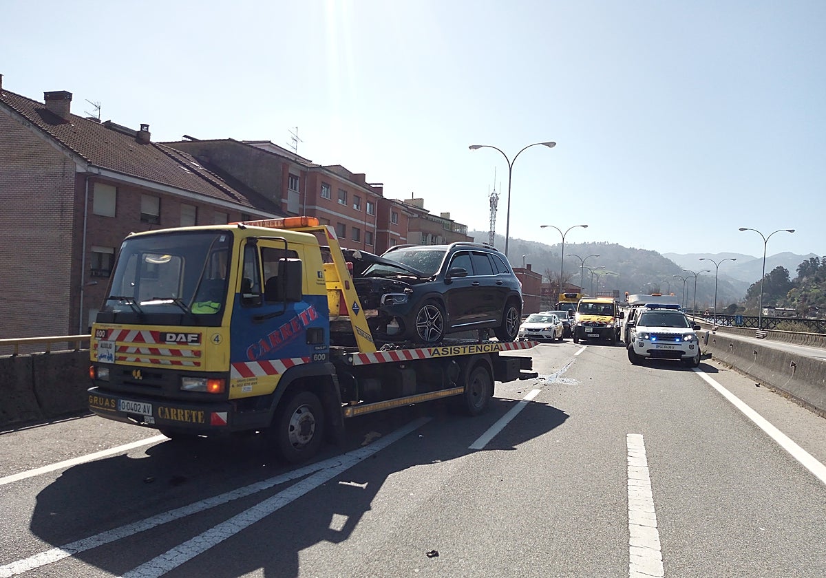 El turismo accidentado siendo retirado de la calzada.