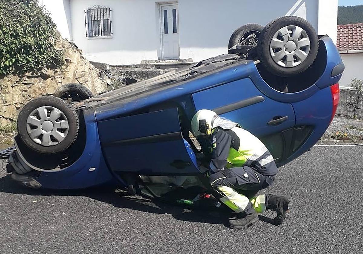 Un bombero revisa el vehículo accidentado.