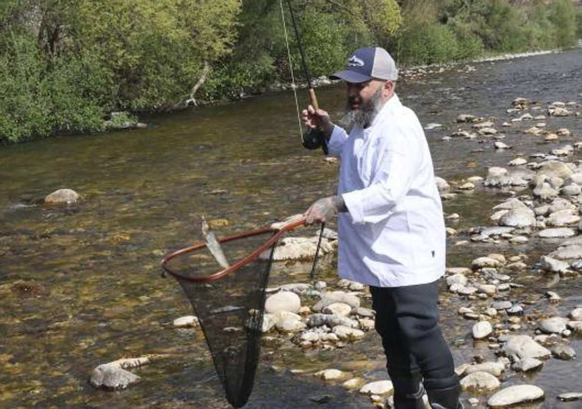 El cocinero David Montes, en el río Aller, en plena captura de una trucha.