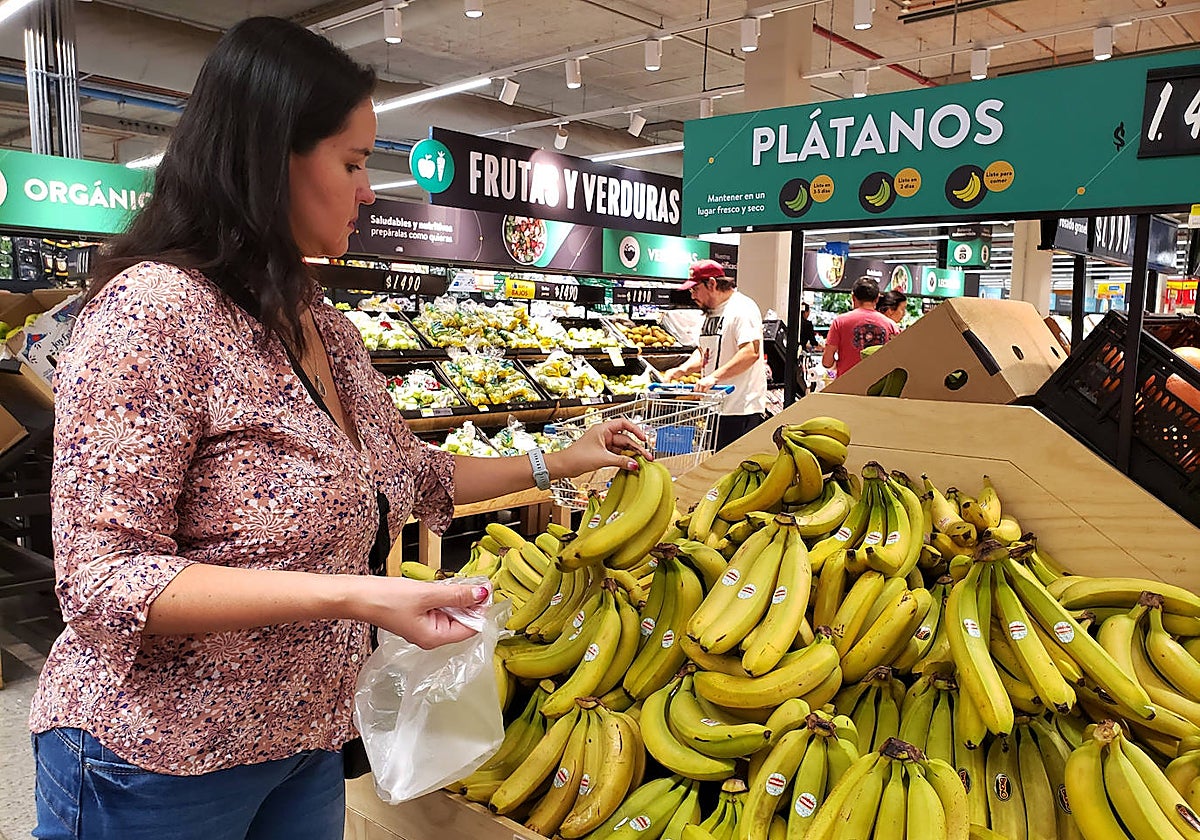 Una mujer compra fruta en un supermercado.